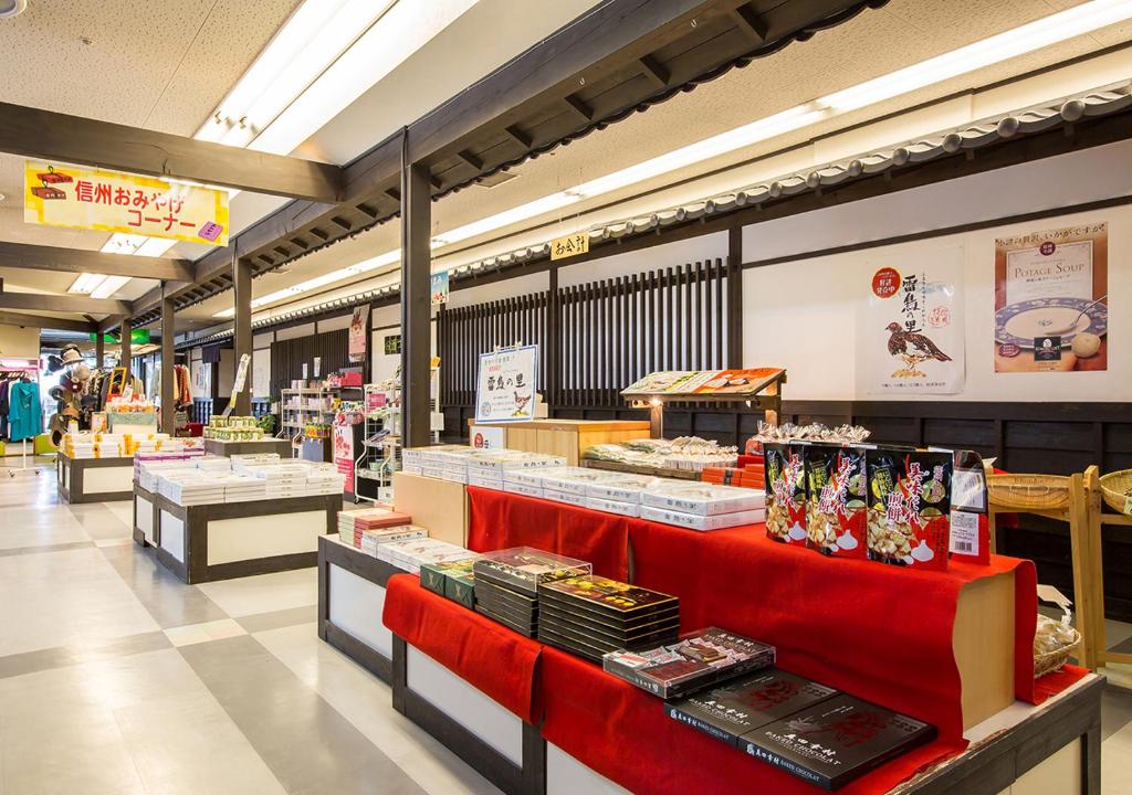un couloir d'épicerie avec un comptoir rouge avec de la nourriture dans l'établissement Komoro Grand Castle Hotel, à Komoro