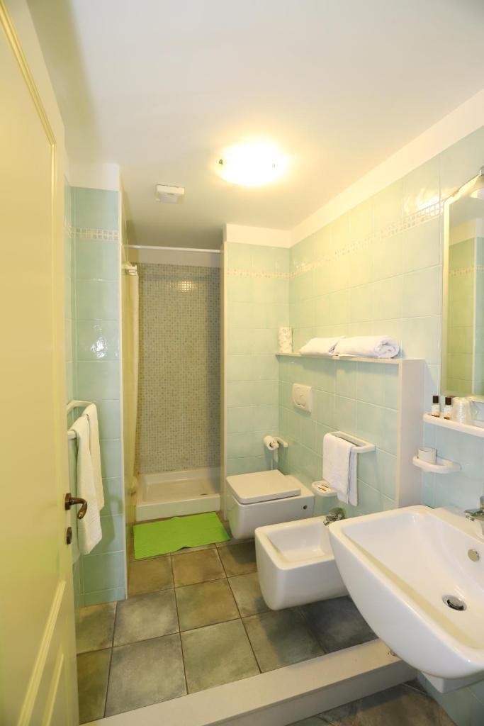 une salle de bain avec un lavabo, des toilettes et une douche dans l'établissement Hotel Celeste, à Marzamemi