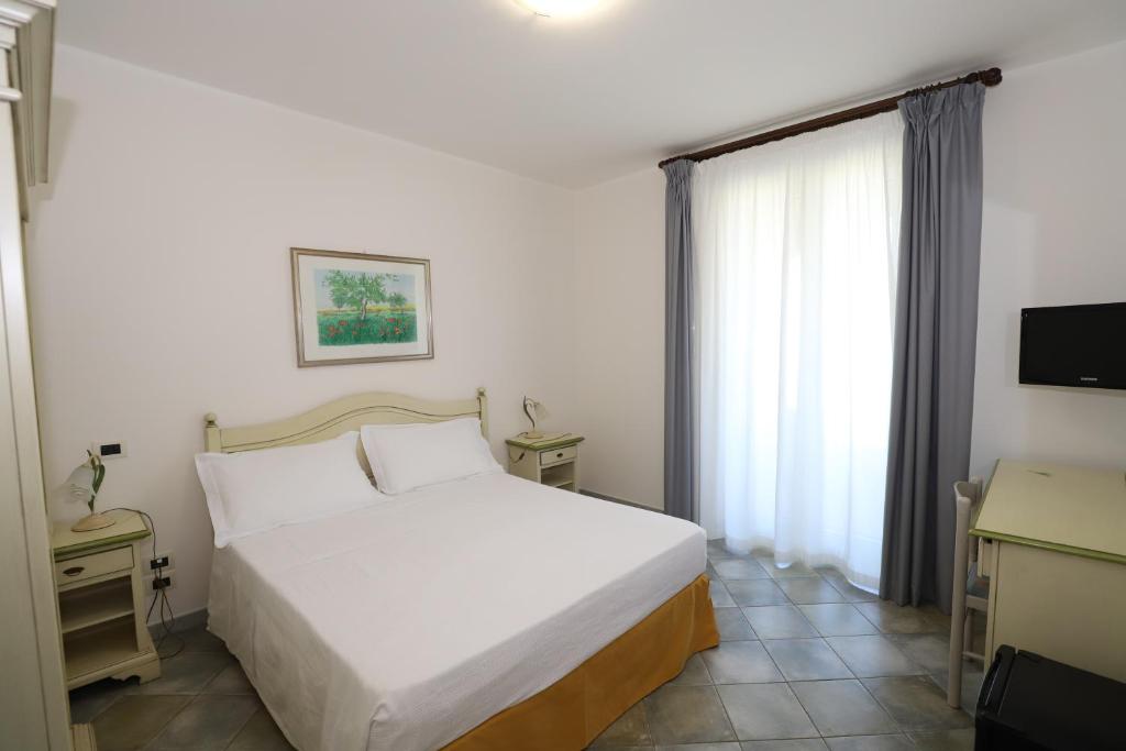 une chambre avec un lit blanc et une fenêtre dans l'établissement Hotel Celeste, à Marzamemi