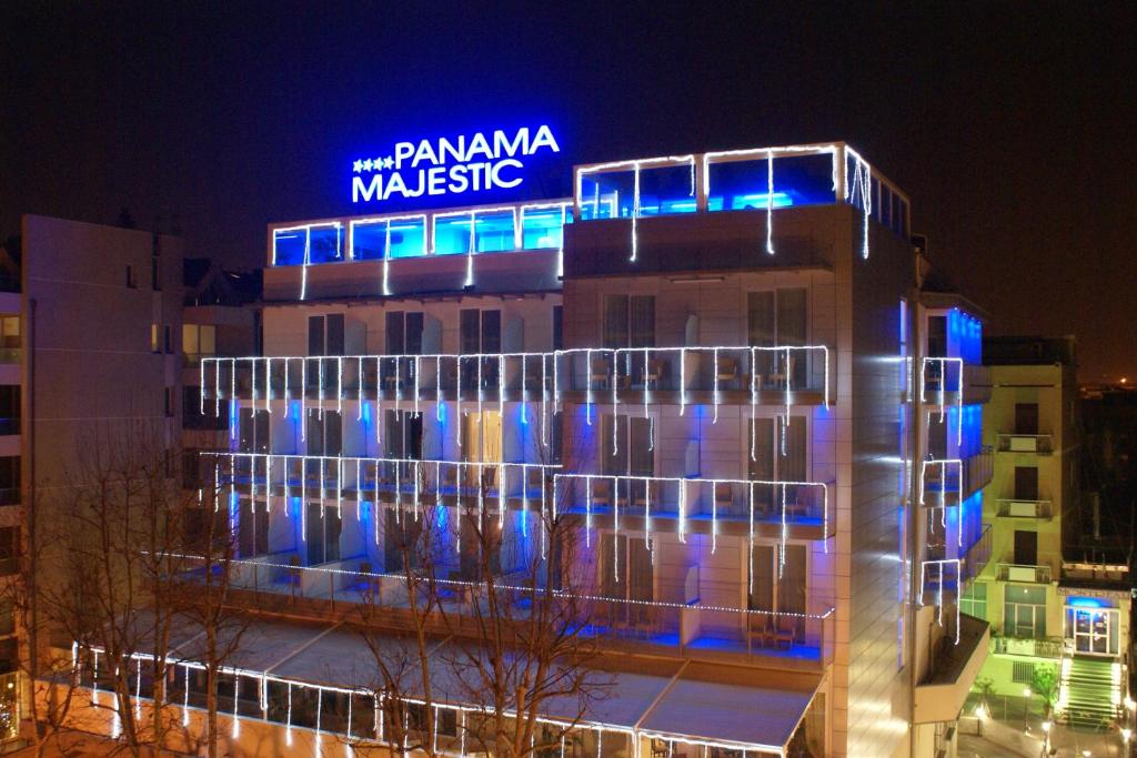un bâtiment avec un panneau bleu au sommet dans l'établissement Hotel Panama Majestic, à Rimini