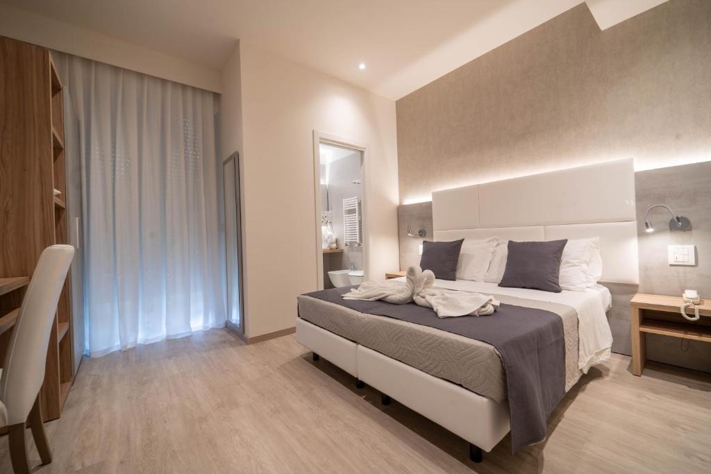une chambre avec un grand lit et un bureau dans l'établissement Hotel Reggiana, à Riccione 45 autres photos