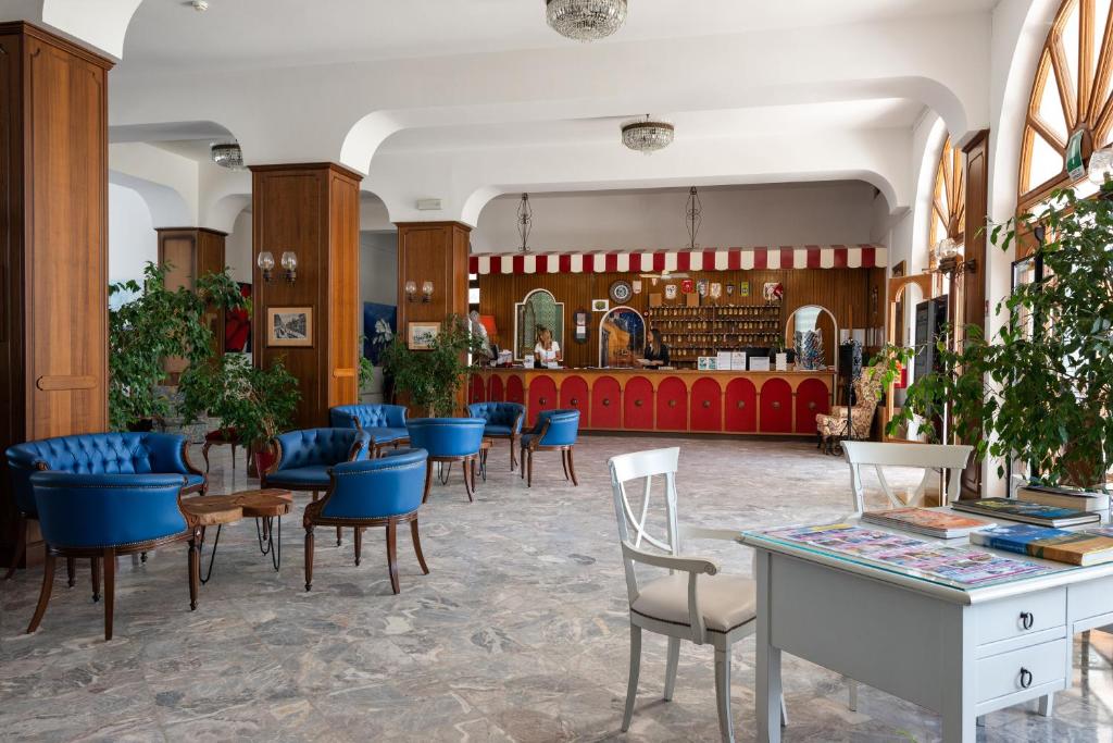 un hall d'un magasin avec des chaises et des tables dans l'établissement Grand Hotel Excelsior, à San Benedetto del Tronto