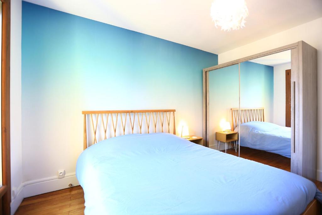 une chambre avec un grand lit blanc et un miroir dans l'établissement La station n° 5, à Annecy