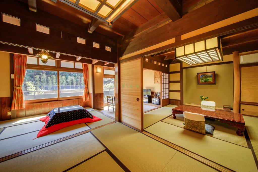 une pièce avec un lit et une table dedans dans l'établissement Shirakabe, à Izu