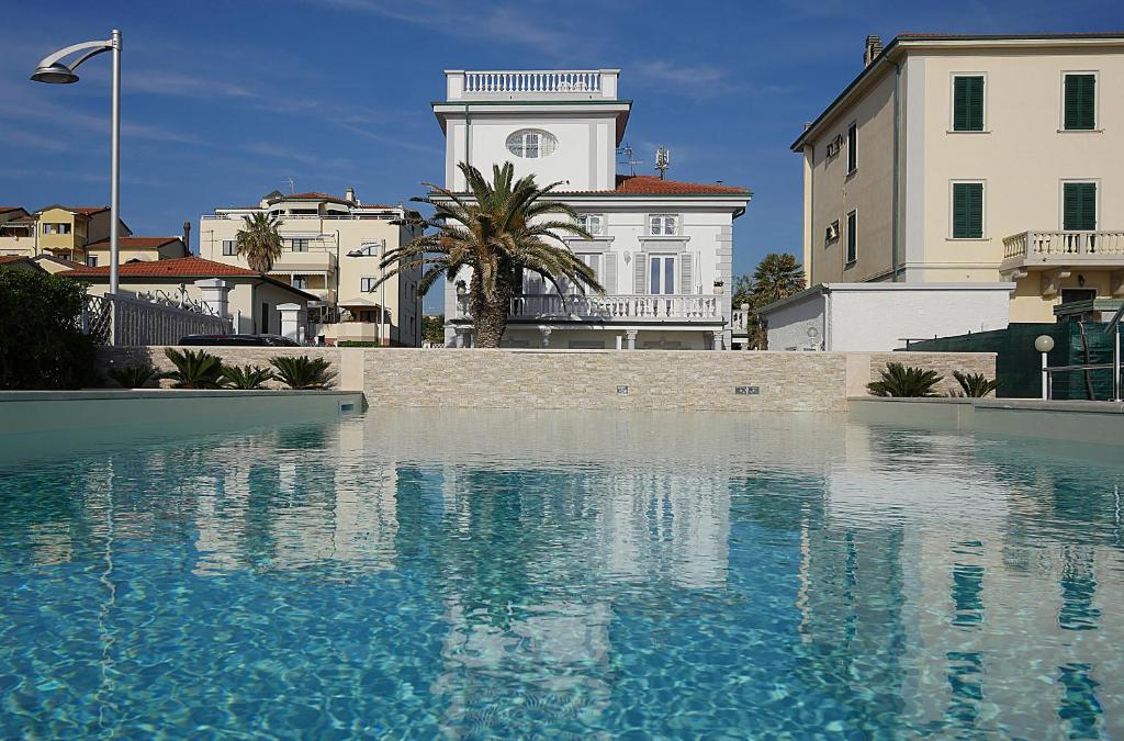 une grande piscine d'eau devant un bâtiment dans l'établissement Residence Villa Piani, à San Vincenzo