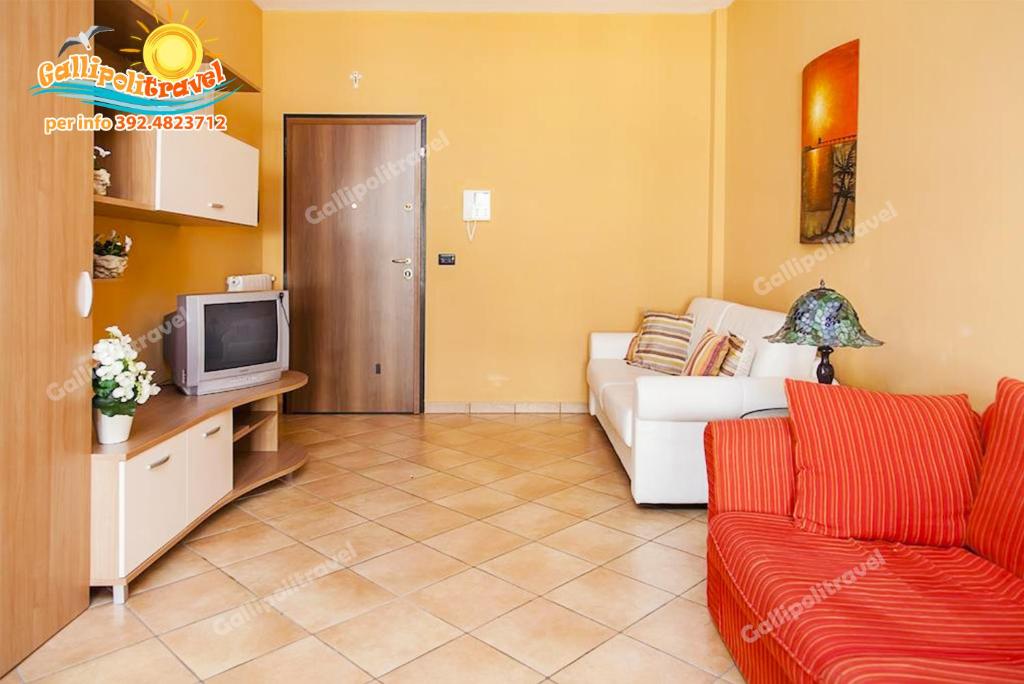 un salon avec un canapé et une télévision dans l'établissement Rosa Virginia Apartment, à Gallipoli