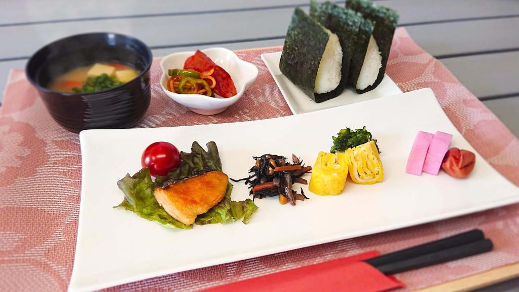 une assiette de nourriture sur une table avec des sushis dans l'établissement Pal Annex Kitakyushu (Love Hotel), à Kitakyūshū