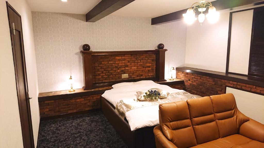 une chambre avec un grand lit et une chaise dans l'établissement Pal Annex Kitakyushu (Love Hotel), à Kitakyūshū