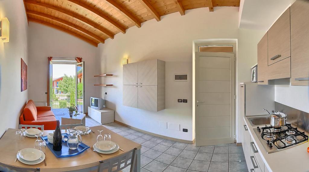 une cuisine et un salon avec une table dans une pièce dans l'établissement Residence Alice, à Dormelletto