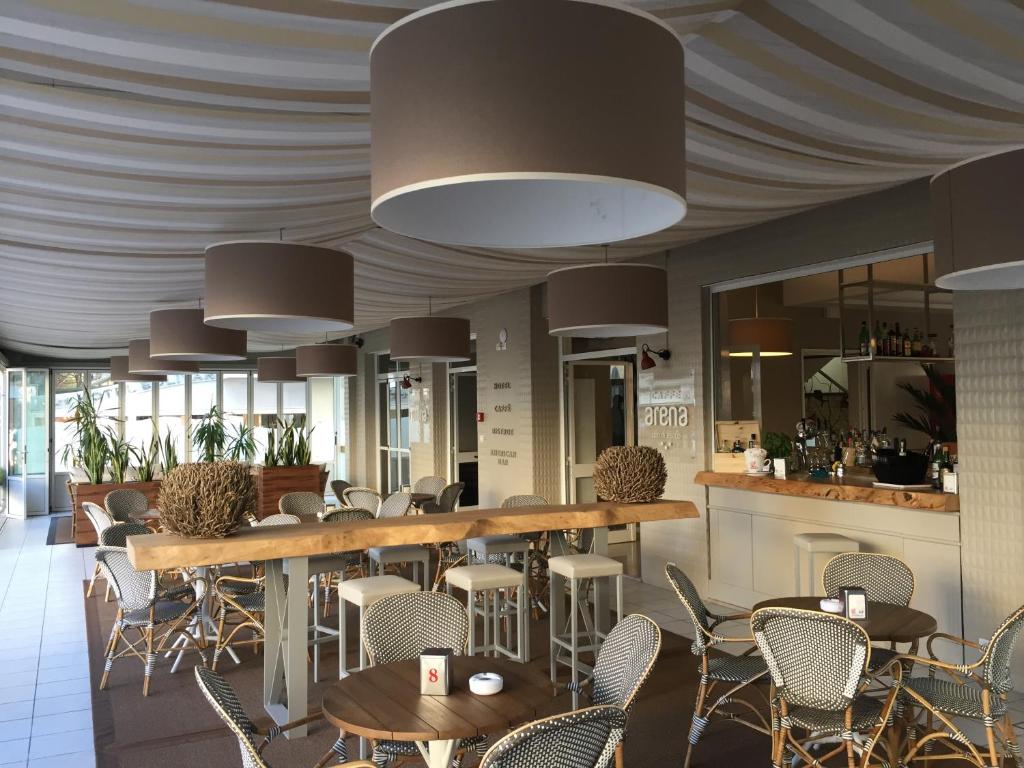 un restaurant avec des tables et des chaises et un bar dans l'établissement Hotel Arena, à Lido di Jesolo 99 autres photos