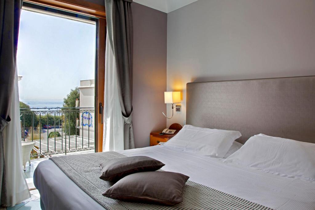 - une chambre dotée d'un lit avec des oreillers et d'une grande fenêtre dans l'établissement Hotel Villa Luisa, à Pouzzoles 51 autres photos