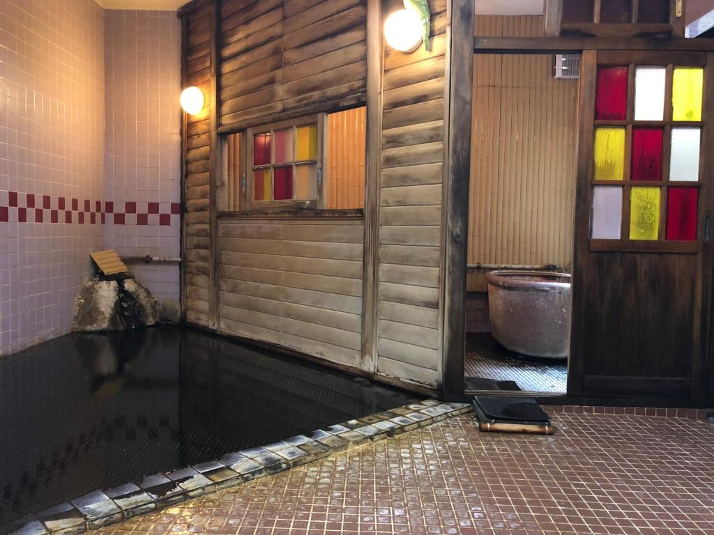 une salle de bains vide avec une baignoire et des toilettes dans l'établissement Tabinoyado Saikawa, à Kuroishi
