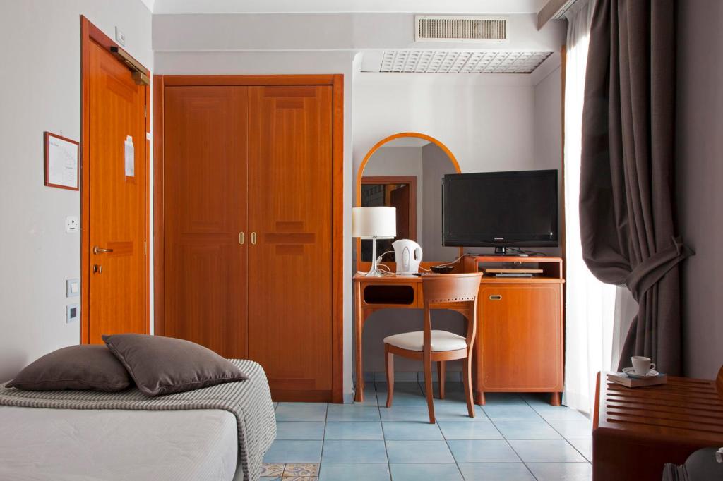 une chambre avec un lit et un bureau avec un ordinateur dans l'établissement Hotel Villa Luisa, à Pouzzoles