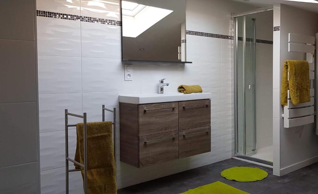 une salle de bain avec un lavabo et un miroir dans l'établissement Gite de kernaet avec piscine, à Plougonvelin