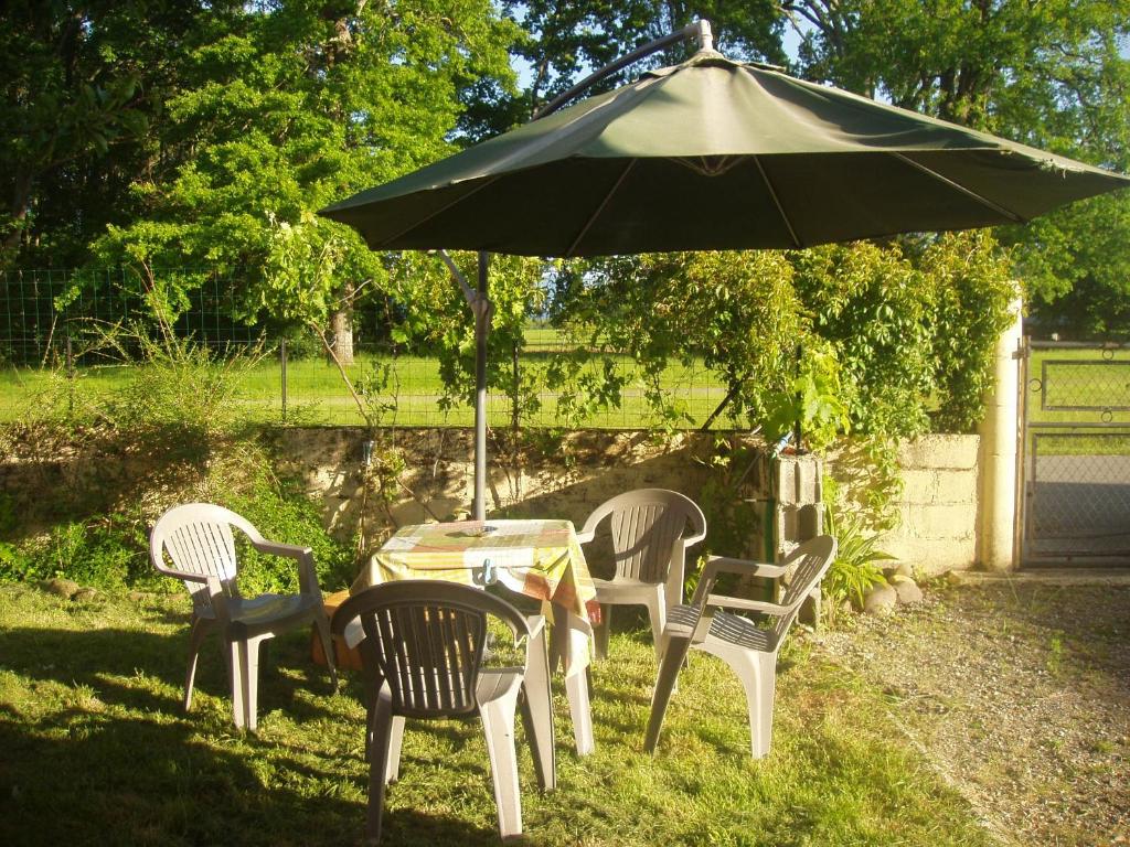 une table avec quatre chaises et un parasol dans l'établissement La petite danseuse, à Franquevielle