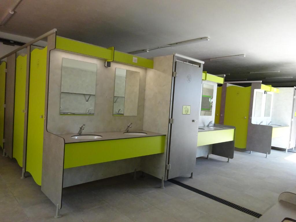 - une salle de bains commune avec deux lavabos et un miroir dans l'établissement Camping Mozziconaccio, à Sainte-Lucie de Porto-Vecchio