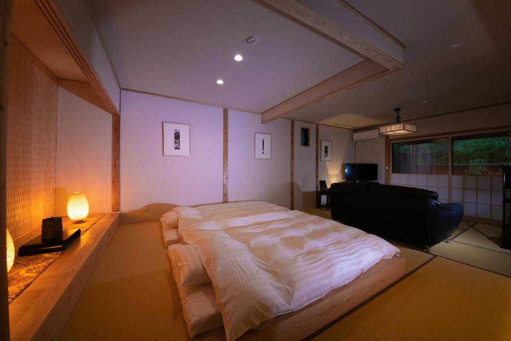 une chambre avec un grand lit dans une pièce dans l'établissement Oyado Den Rikyu, à Yufu 37 autres photos