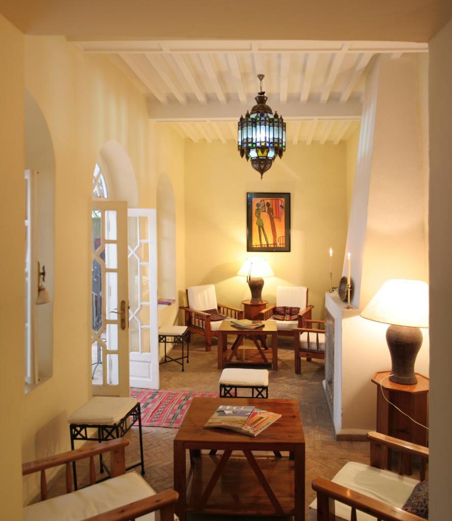d'un salon avec des tables, des chaises et un lustre. dans l'établissement Dar Loulema, à Essaouira