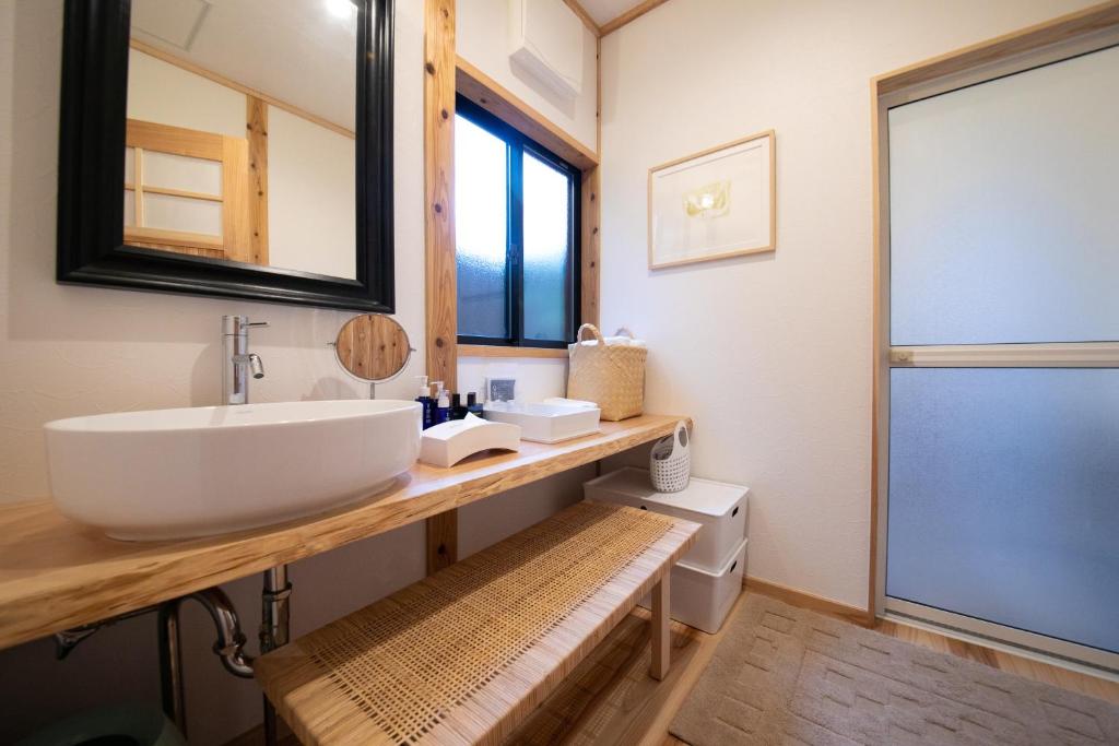 une salle de bain avec un lavabo et un miroir dans l'établissement Oyado Den Rikyu, à Yufu