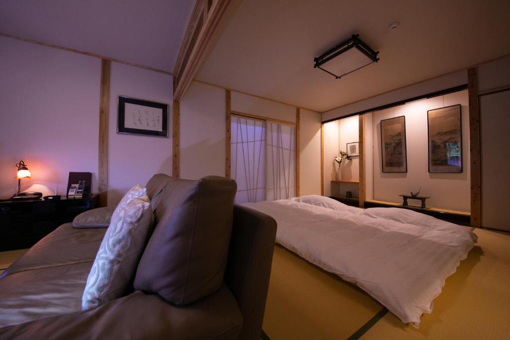 une chambre avec un lit et un canapé dans l'établissement Oyado Den Rikyu, à Yufu