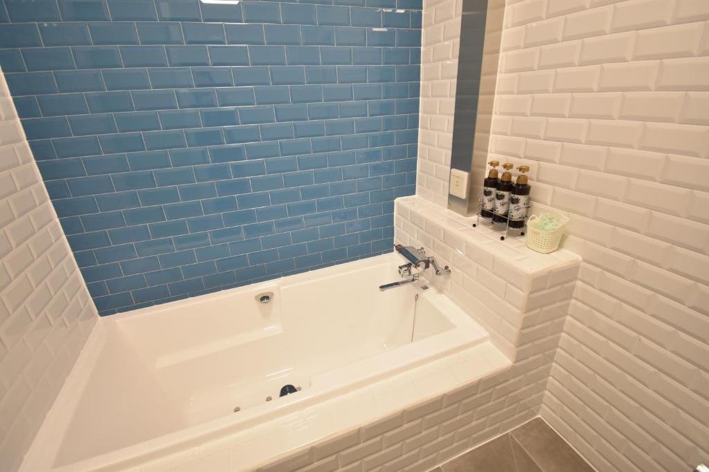 La salle de bains est pourvue d'une baignoire et de carrelage bleu. dans l'établissement Hotel Pinon - Adult Only, à Kai 6 autres photos