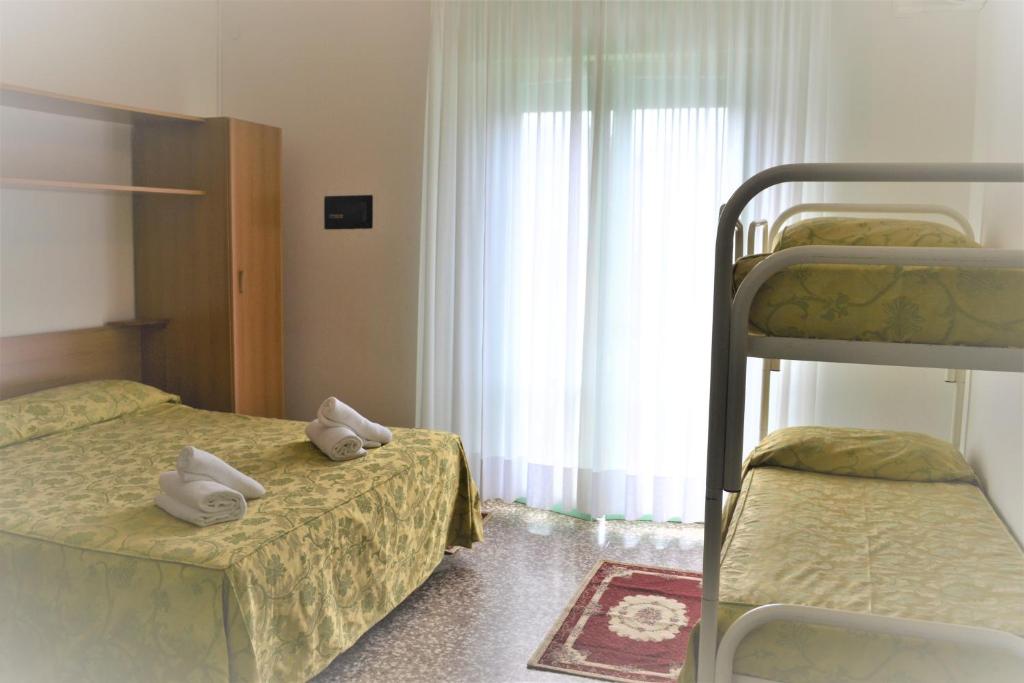 une chambre avec deux lits superposés et une fenêtre dans l'établissement Hotel Mirage, à Lido di Jesolo