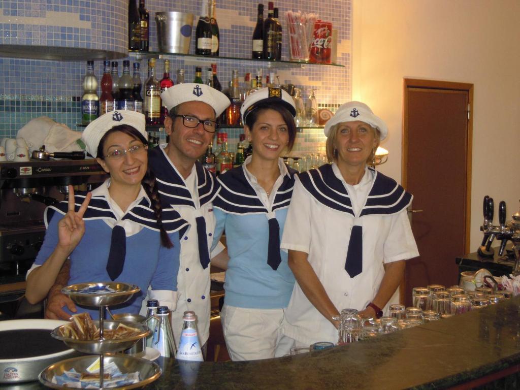 un groupe de quatre personnes dans des chapeaux de chefs debout à un comptoir dans l'établissement Hotel Confort, à Cattolica 27 autres photos