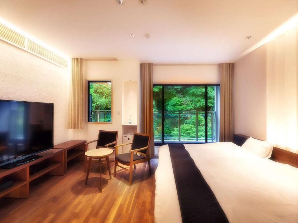 une chambre d'hôtel avec un grand lit et une télévision dans l'établissement Hanare Matsushimakaku, à Aizuwakamatsu