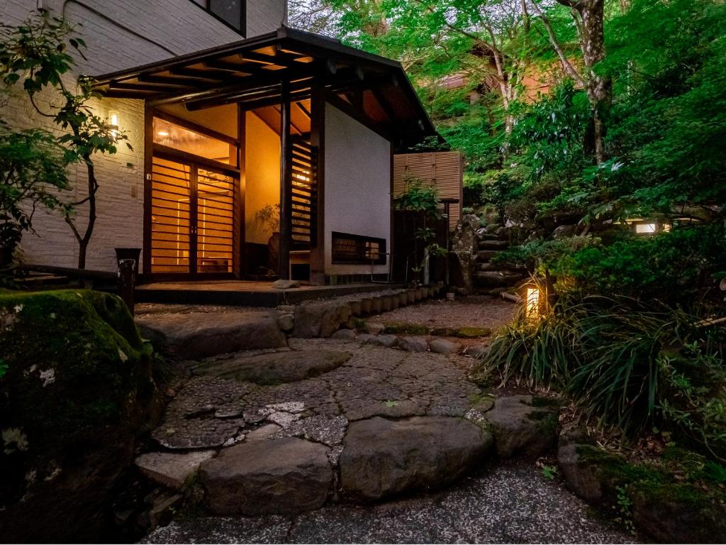 une petite maison avec un chemin en pierre menant à elle dans l'établissement Hakone Onsen Sanso Nakamura, à Hakone