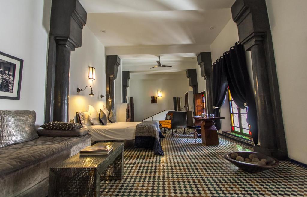 un salon avec un canapé et un lit dans l'établissement Riad Laaroussa, à Fès