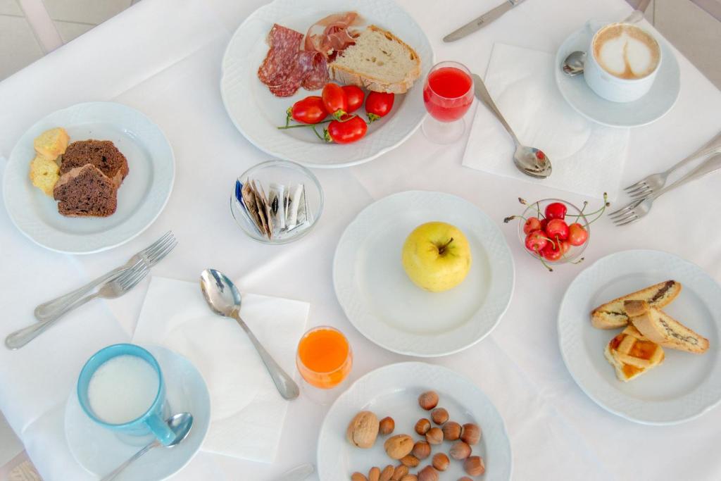 une table blanche avec des assiettes de nourriture dessus dans l'établissement Hotel D'Atri, à Montesilvano