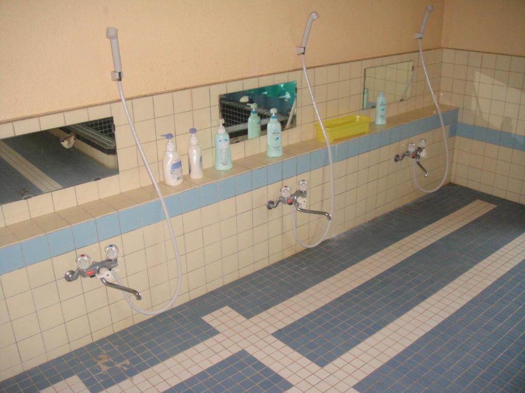 La salle de bains est pourvue de 2 robinets de douche et d'un miroir. dans l'établissement Matsuichi, à Hamamatsu