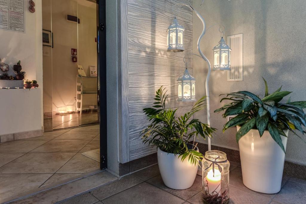 un hall avec deux plantes en pot et deux lumières dans l'établissement Renzo Hotel, à Cesenatico