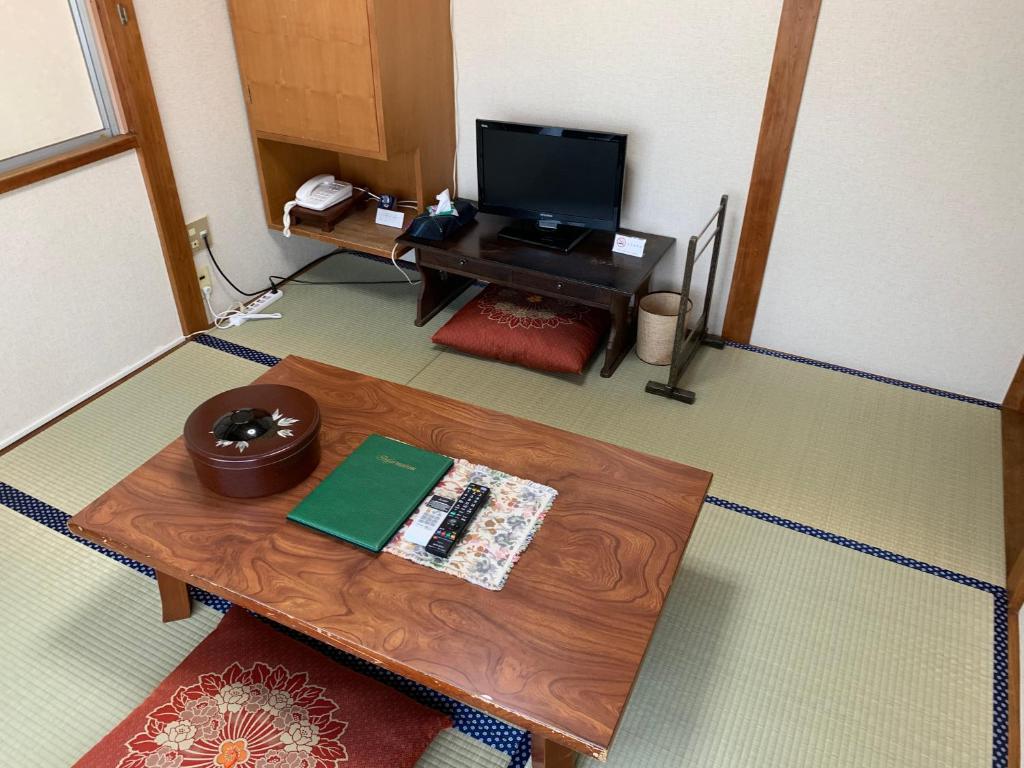 - un salon avec une table basse et une télévision dans l'établissement Hinodeya, à Itō 37 autres photos
