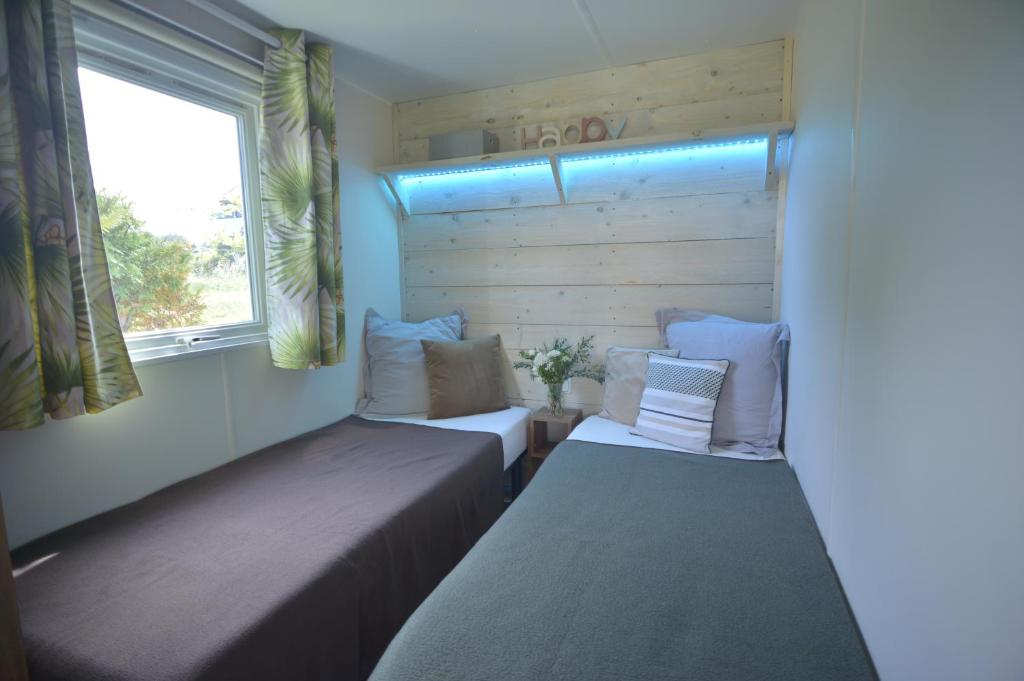 deux lits dans une petite pièce avec une fenêtre dans l'établissement Sas Robrecht, à Saint-Tropez