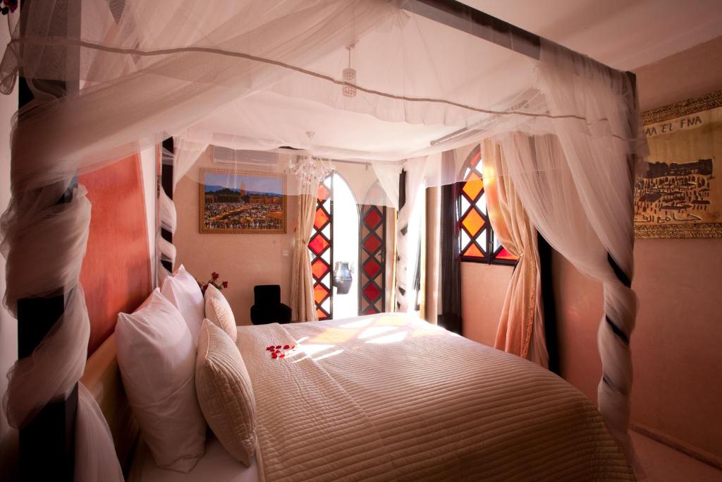 une chambre avec un lit blanc à baldaquin dans l'établissement Riad Le Rubis, à Marrakech