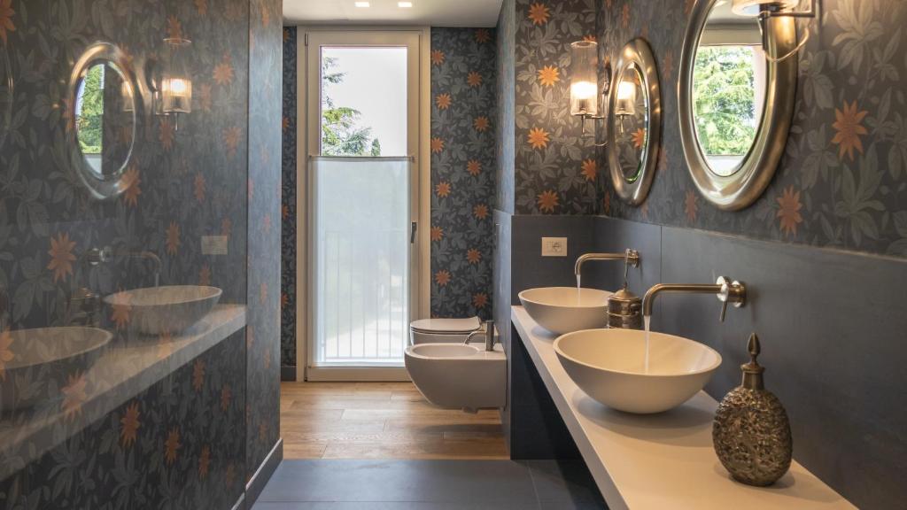 une salle de bain avec deux lavabos et deux miroirs dans l'établissement Villa Collivo, à Lazise