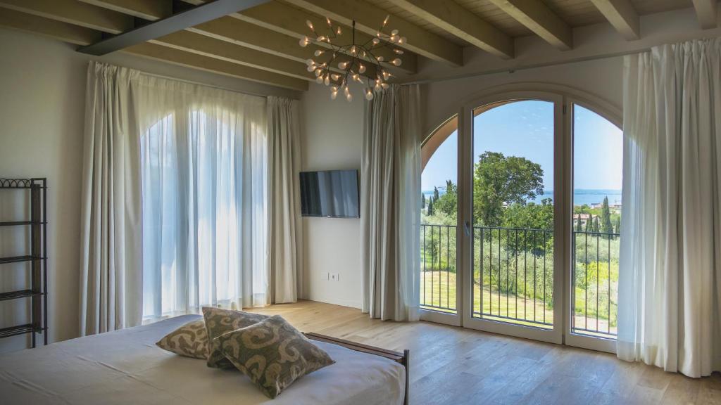 une chambre avec un lit et une grande fenêtre dans l'établissement Villa Collivo, à Lazise