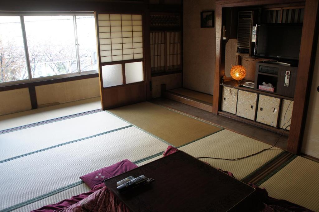 une chambre avec des portes et des fenêtres dans l'établissement Miyoshiya Ryokan, à Tanabe