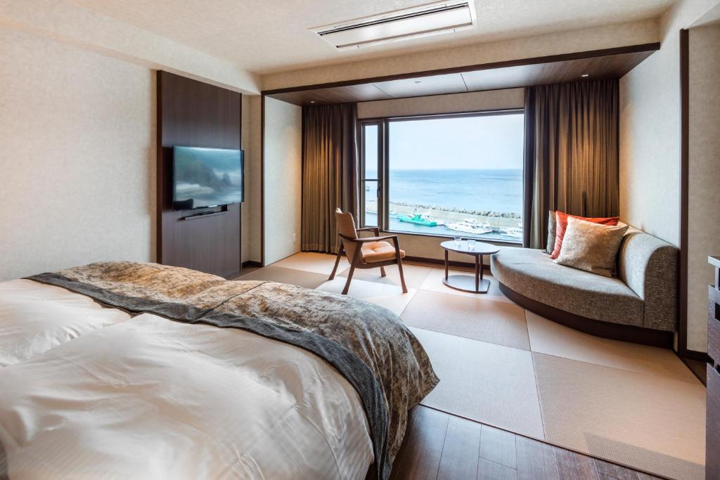 une chambre d'hôtel avec un lit et une vue sur l'océan dans l'établissement Kitakobushi Shiretoko Hotel & Resort, à Shari 37 autres photos