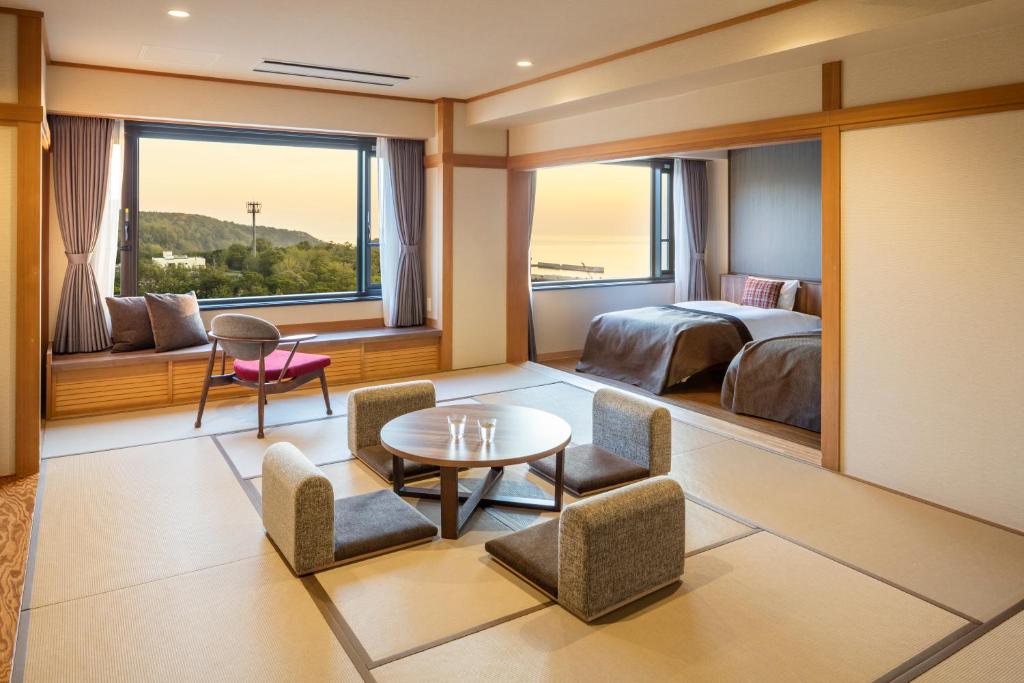 une chambre d'hôtel avec un lit, une table et des chaises dans l'établissement Kiki Shiretoko Natural Resort, à Shari
