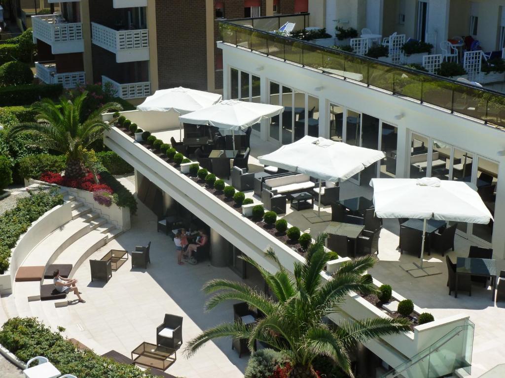 une vue aérienne sur un bâtiment avec des tables et des parasols dans l'établissement GFH - Hotel Ruhig, à Marotta
