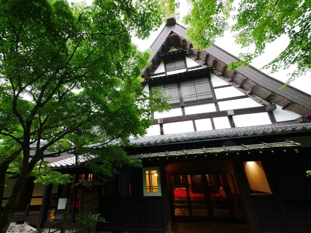 une vieille maison avec un toit à la mansarde dans l'établissement Hazu Gassyo, à Shinshiro