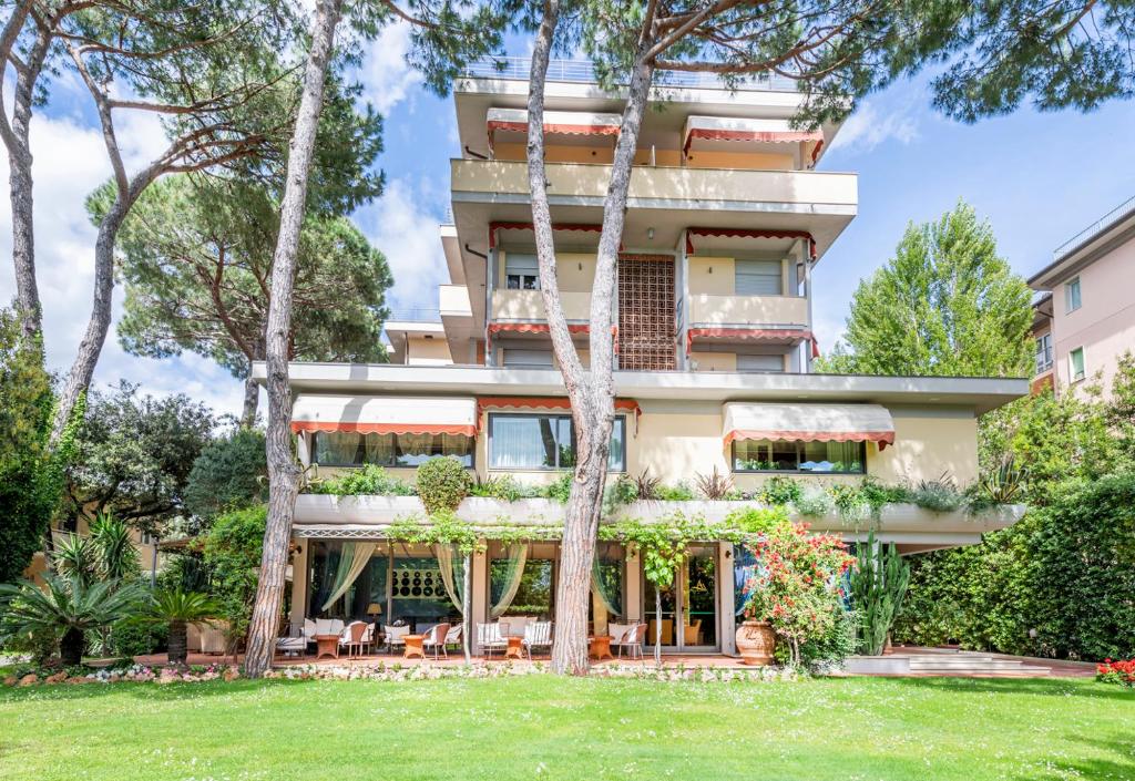 un bâtiment avec des arbres devant dans l'établissement Hotel Andreaneri, à Marina di Pietrasanta