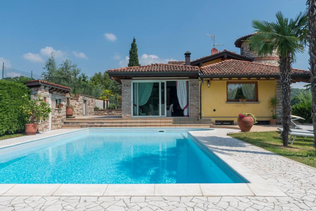 une piscine devant une maison dans l'établissement Villa Cristina, à Villa Pedergnano