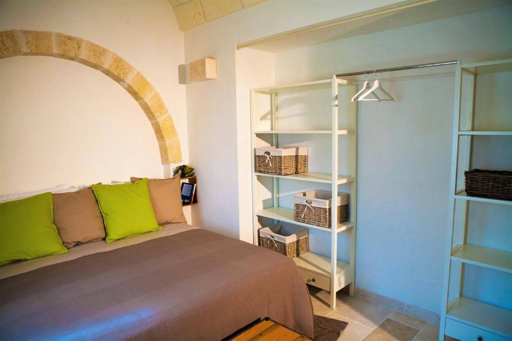 une chambre avec un lit et une étagère dans l'établissement Villa Vittoria, à Cisternino