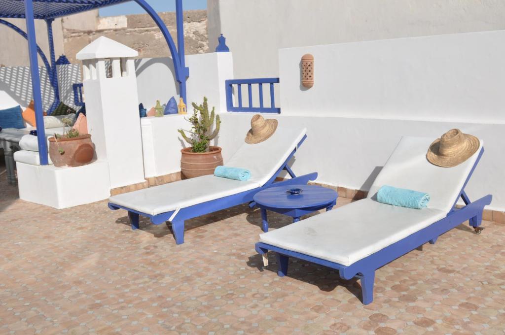 deux chaises bleues et une table dans une pièce dans l'établissement Riad le Consulat - Private Riad, Breakfast included, à Essaouira