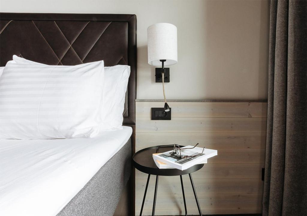 une chambre avec un lit et une table avec une lampe dans l'établissement Langley Hôtel Tignes 2100, à Tignes