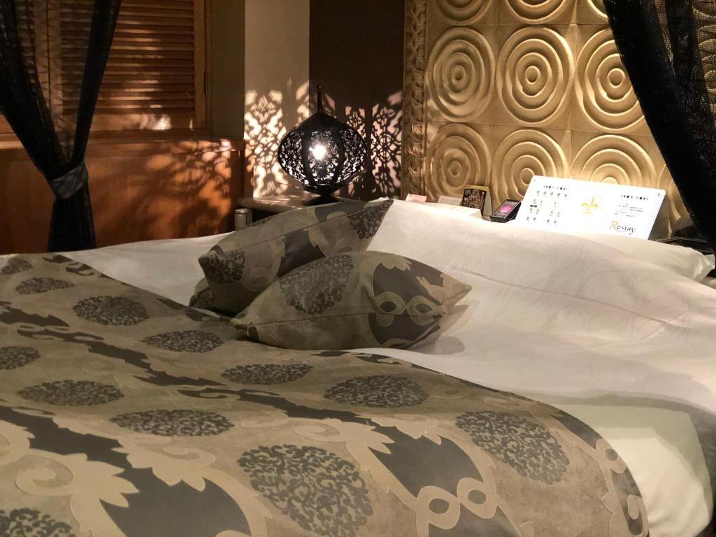 un lit avec une couette et des oreillers dessus dans l'établissement Restay Mito (Adult Only), à Mito