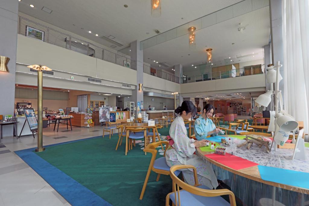 Deux femmes assises à une table dans un magasin dans l'établissement Kyukamura Shikanoshima, à Fukuoka